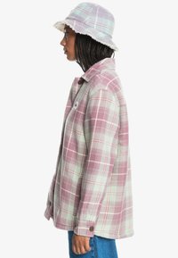  rutig skjorta i pastellgrön och lavendel med en strukturerad krage och knapplås; bucket hat i matchande färger med en texturerad kant.
