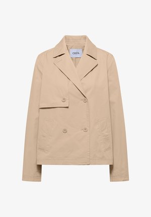 Veste beige croisée à quatre boutons, col à revers en encoche, deux poches avant, et un détail d'une patte inclinée sur le côté droit de la poitrine.