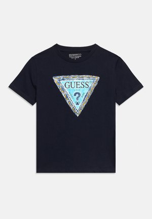 T-shirt noir à manches courtes avec un grand logo triangulaire bleu au centre affichant le mot "GUESS" et un point d'interrogation à l'intérieur.