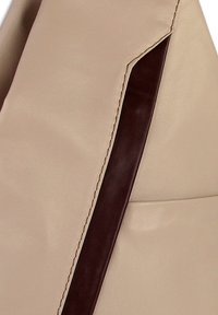 Beigefarbene Ledertasche mit glatter Oberfläche, versehen mit einem dunkelbraunen Akzentstreifen und kontrastierenden Nähten entlang der Kante.