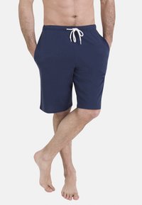 Shorts bleu marine en tissu doux, avec une ceinture élastique à cordon, des poches latérales et une coupe décontractée.