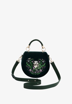 Zelena baršunasta torbica s pozlaćenim detaljima, koja na prednjem dijelu ima izvezenu jazavčicu okruženu cvjetnim elementima. Uključuje odvojivi remen.