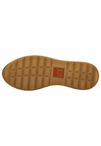 Semelle de chaussure en caoutchouc de couleur beige, avec des motifs de grip texturés et un logo rectangulaire au centre. Design à bout arrondi.