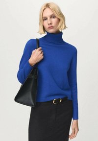 Maglione girocollo lavorato a maglia di un blu reale con maniche lunghe, abbinato a una borsa in pelle nera e a una cintura nera. Texture liscia in tutto il capo.