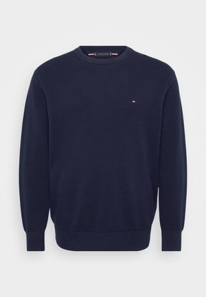 Suéter azul marino hecho de tejido de punto texturizado, con un escote redondo y un pequeño logo en el pecho. Con puños y dobladillo acanalados.