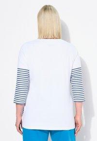 Weißes T-Shirt mit drei Viertel Ärmeln in Navy- und Weißstreifen, lockere Passform, glatte Textur und rundem Ausschnitt.