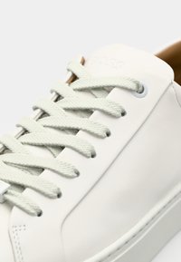 Adidași albaștri din piele cu șnururi texturate de culoare verde deschis, vârf rotunjit, detalii logo subtile și un finisaj neted pe partea superioară.