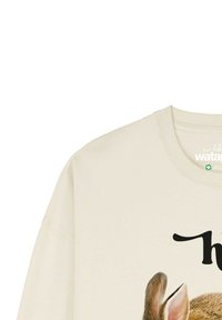 Sweatshirt de couleur crème avec un graphique de lapin sur le devant et un texte en noir. Le tissu semble doux avec une coupe décontractée.