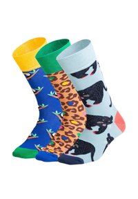Tre par sokker med forskellige design: gule med fugle, brune med leopardprint og lyseblå med sorte katteillustrationer.