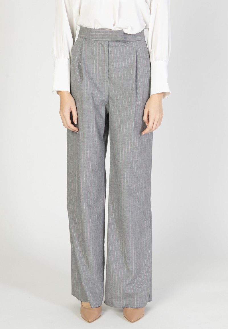 Pantaloni grigi a gamba larga con righe verticali rosa, dotati di pieghe e vita alta, abbinati a tacchi beige. Tessuto dalla texture liscia.