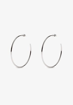 Boucles d'oreilles en argent avec un design minimaliste, présentant une forme circulaire lisse et une finition polie, maintenues par une fermeture à tige.