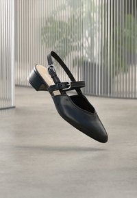 Μαύρο δερμάτινο παπούτσι slingback με μυτερή μύτη, με ιμάντα με αγκράφα και χοντρό τακούνι. Λείο υλικό και μινιμαλιστικός σχεδιασμός.