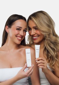 Kaksi naista pitävät valkoisia ihonhoitotubeja, joissa lukee "elinor BB cream" tyylikkäällä ja minimalistisella muotoilulla. Pakkaus sisältää puhtaan fontin ja yksinkertaisia muotoja.