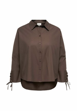 Chemise marron à manches longues avec boutons, col pointu et détails de laçage aux poignets, avec un ourlet légèrement plus long derrière.