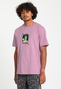 Lila katoenen t-shirt met een centraal zwart grafisch ontwerp van een ruimteschip en torens, met steraccenten. Ontspannen pasvorm en korte mouwen.