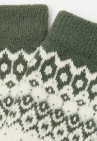 Strikkede fingerløse handsker i mørkegrøn med akcenter i creme mønster. Blød tekstur med geometriske motiver og ribbede manchetter.