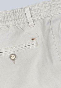 Light gray shorts with a textured fabric, elastic waistband, back pocket with button, and a small logo plaque near the pocket.