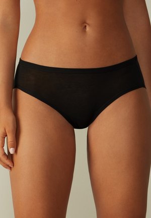 Schwarze Bikini-Unterwäsche aus durchsichtigen Stoff, mit einem glatten Bund und schlichtem Design, das minimale Bedeckung zeigt.