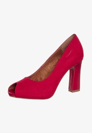 Czerwony zamszowy damski but na wysokim obcasie typu peep-toe z szerokim obcasem i brązową wkładką, na białym tle.