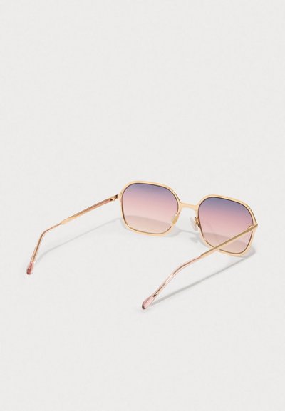 Gafas de sol de metal dorado con lentes cuadrados, que presentan un tono degradado en rosa. Brazos delgados y elegantes con una ligera curva en los extremos.
