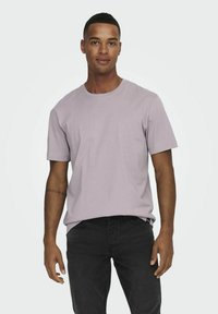 Hellblau-lila Kurzarm-T-Shirt mit Rundhalsausschnitt, aus weichem Baumwollstoff gefertigt. Verfügt über eine lockere Passform und dezente Nähdetails.