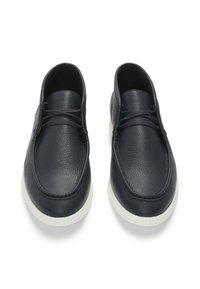 Scarpe in pelle blu navy con superficie texturizzata, dotate di punta rotonda, profilo basso e suole in gomma bianca. I lacci neri completano il design.