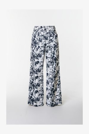 Spodnie o szerokich nogawkach z białej tkaniny w czarne plamki. Posiadają dopasowaną talię i przednie kieszenie, zapewniające funkcjonalność.