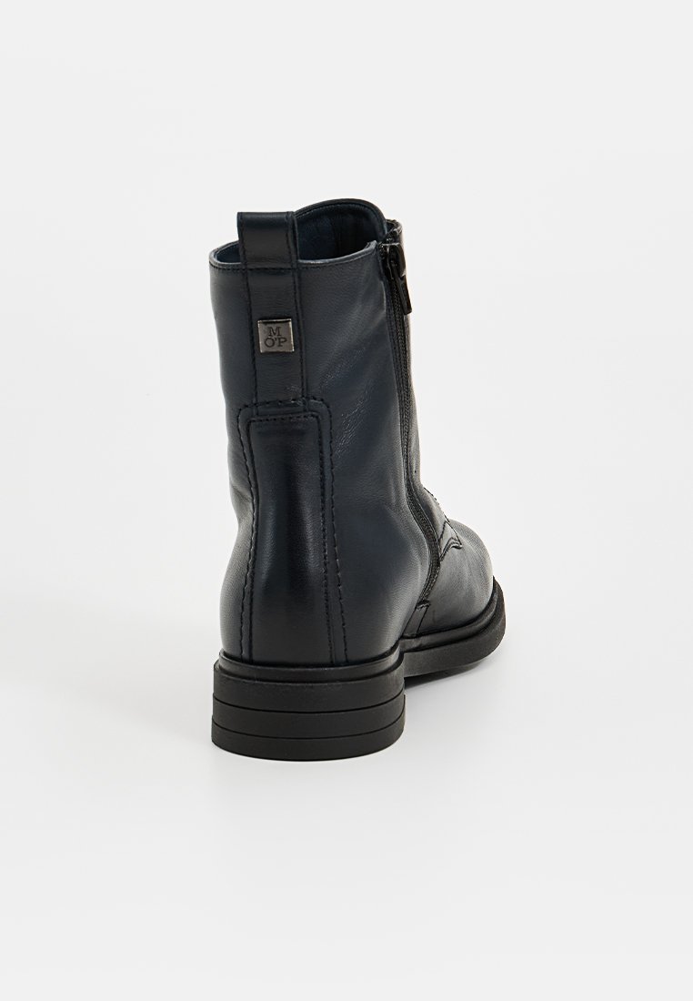 Zwarte leren enkellaars met een zijrits, ronde neus en lage blokhak. Bevat een metalen logo-accent bij de rits.