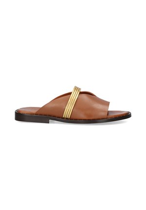 Sandalia de cuero marrón con tiras superiores cruzadas y acento metálico dorado. Suela plana negra, textura suave y diseño minimalista.