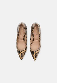 Talons hauts à imprimé léopard avec une finition brillante, bout pointu et intérieur nude, présentant un design à enfiler par ALDO.