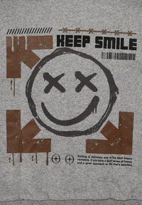 Grauer Kapuzenpullover mit einem großen braunen Smiley-Gesicht mit gekreuzten Augen, dem Text "KEEP SMILE" und grafischen Elementen wie Streifen und Mustern.