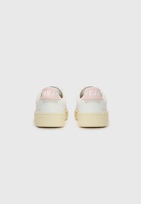 White sneakers with a smooth leather upper, pink heel tab, beige rubber outsole, and embossed "VEJA" branding on the back.