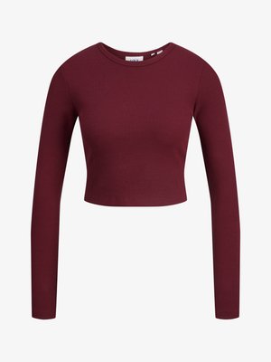 Burgunderfarbenes Crop-Top, lange Ärmel, gerippte Textur, runder Ausschnitt, weiches Material, taillierte Passform. Etiketten am Hals sichtbar.