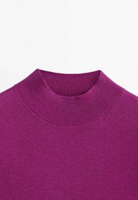 Paarse gebreide trui met een hoge, geribbelde col. Op een witte achtergrond weergegeven.