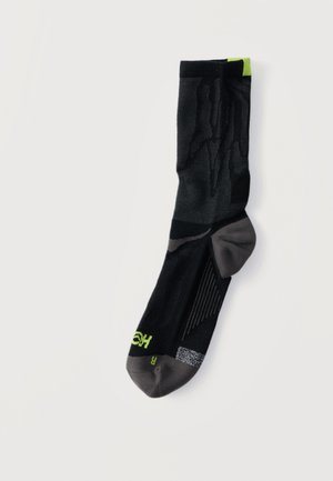 Fekete és szürke atlétikai zokni neonzöld részletekkel, texturált mintákkal és párnázottsággal a sarok és a lábujjak területén, jobb lábra jelölve.