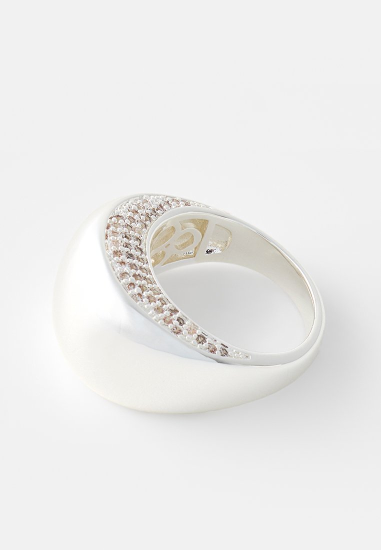 Silberring mit einem glatten, abgerundeten Design und einem gebogenen Ringband, verziert mit kleinen pinkfarbenen Steinen entlang einer Kante.