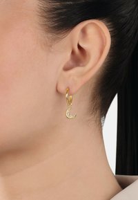 Pendientes de aro dorados con un colgante de luna creciente. La luna presenta una superficie texturizada y brillante, que añade detalle e interés visual.