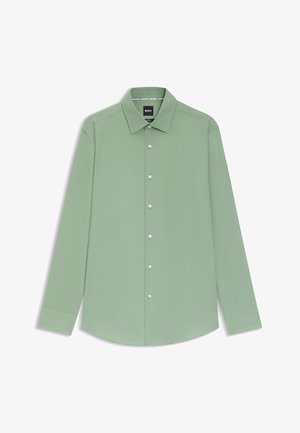 Camicia da uomo a manica lunga di colore verde chiaro con colletto a punta e bottoni bianchi, distesa su uno sfondo bianco.