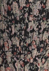 Blumenkleid mit schwarzem Grund und Rüschenlagen. Das Design umfasst pinke, weiße und grüne Blumen auf einem strukturierten Stoff.