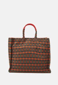 Sac fourre-tout en tissu à motifs, comprenant des teintes de vert, d'orange et de noir. Deux courtes poignées rouges. Forme rectangulaire avec des côtés structurés.