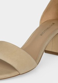 Μπεζ σουέντ ανοιχτή σάνδαλα με φαρδιά μπροστινή λουρίδα, τακούνι τύπου block και λεία εσωτερική σόλα με την ετικέτα "Peter Kaiser."