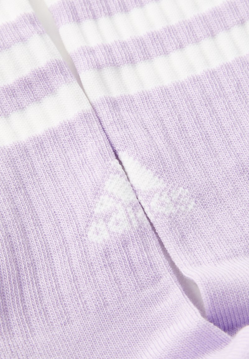 Lilac socks featuring white stripes, ribbed texture, and an embossed white logo. Soft material designed for comfort and style.