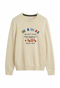 Crème-kleurige sweatshirt gemaakt van zachte stof, met kleurrijke maritieme vlaggen en geborduurde tekst aan de voorkant. Geribde manchet- en zoomdetails.