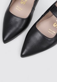 Zapatos de cuero negro con punta afilada y acabado mate, con un diseño de cortes redondeados. Presenta una plantilla MemoryGel para mayor comodidad.
