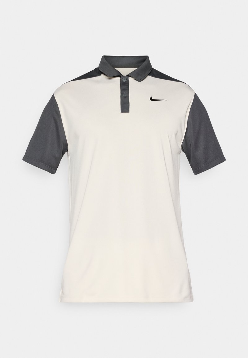 Nike Polo-Shirt in Beige und Dunkelgrau, mit einem knopfbaren Kragen, kurzen Ärmeln und einem dezenten Logo auf der Brust. Glatte Textur.