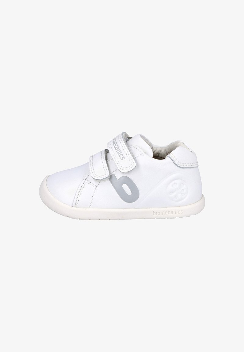 Zapatillas blancas para niños con dos correas de velcro, hechas de cuero. Presentan un logo gris y una suela texturizada para mayor agarre. Diseño de punta redondeada.
