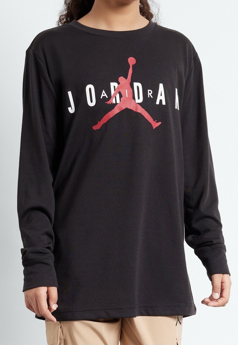 Svart långärmad skjorta i bomull med en röd Jumpman-logga i mitten och texten "JORDAN" i vita bokstäver.