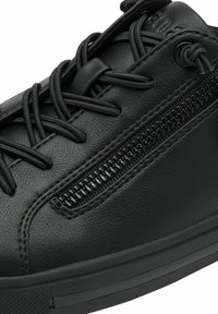 Schwarze Leder-Sneaker mit Schnürverschluss, seitlichem Reißverschlussdetails, strukturiertem Obermaterial und flacher gummierter Sohle.