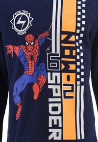 Navy blue long-sleeve t-shirt featuring a graphic of Spider-Man in red and blue, with white and orange text and accent lines.