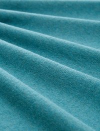 Tkanina w odcieniu niebiesko-zielonym, charakteryzująca się gładką teksturą z widocznymi fałdami i subtelnymi wariacjami odcienia, co wskazuje na lekki, miękki materiał.
